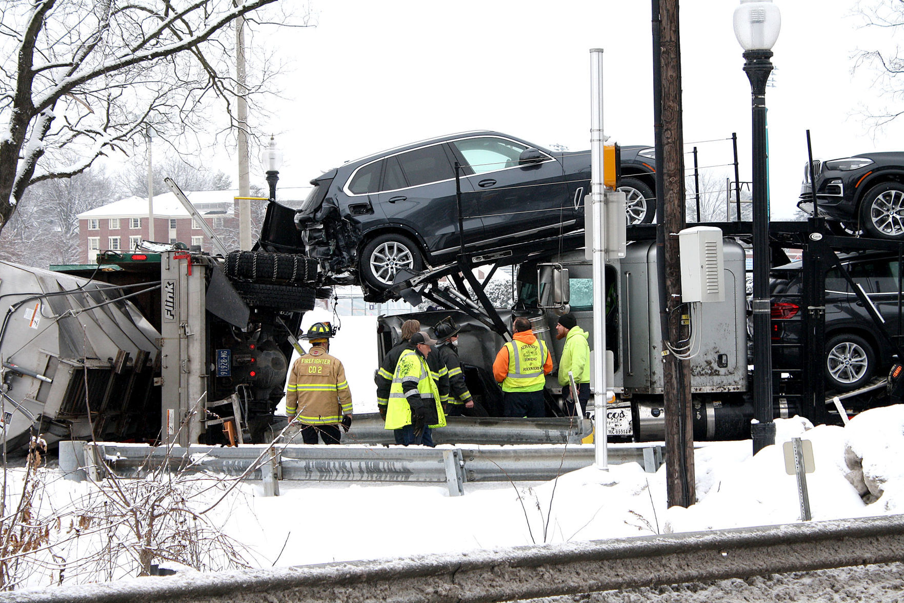 Auto carrier and plow truck collide on snowy roadway